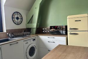 een keuken met een koelkast en een wasmachine bij Tout à pied Dourdan Appartement in Dourdan +9 foto's