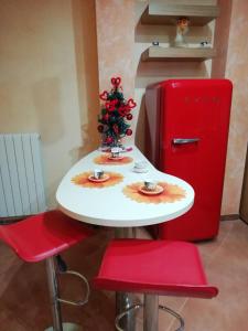 a table with a christmas tree and a red refrigerator at Sole&Mare in Monopoli