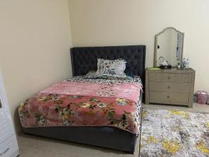 a bedroom with a bed and a dresser and a mirror at Zen Hideaway - Sleek Furnished Sanctuary in Ajman 