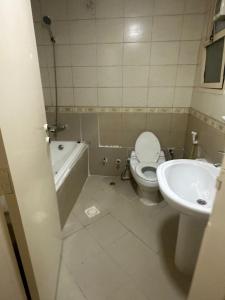 a bathroom with a toilet and a sink at Zen Hideaway - Sleek Furnished Sanctuary in Ajman 