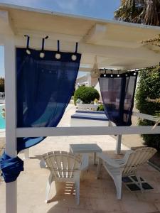 a pergola with blue curtains and a table and chairs at Sole&Mare in Monopoli