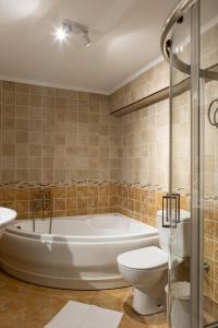 een badkamer met een bad, een toilet en een wastafel bij Gaia The Stone Cottage in Kórinthos +32 foto's