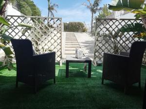 a patio with two chairs and a table in the grass at Sole&Mare in Monopoli