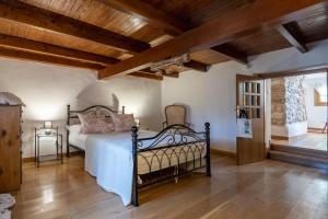 een slaapkamer met een bed en een houten plafond bij Gaia The Stone Cottage in Kórinthos
