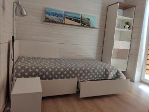 a small bedroom with a bed and shelves at Holiday home near sea beach & pine forest in Riga