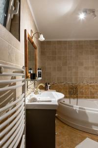 een badkamer met een wastafel en een ligbad bij Gaia The Stone Cottage in Kórinthos