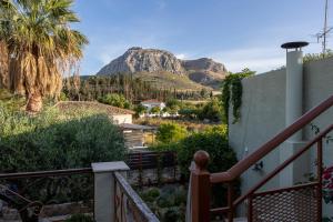 een huis met een balkon met een berg op de achtergrond bij Gaia The Stone Cottage in Kórinthos