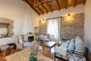 een woonkamer met een stenen muur bij Gaia The Stone Cottage in Kórinthos