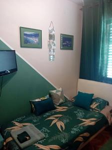 a bedroom with a bed with a green blanket at Guest House Cinderella in Herceg-Novi