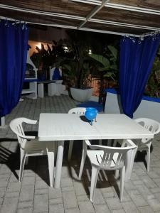 a white table and chairs with a blue bowl on it at Sole&Mare in Monopoli