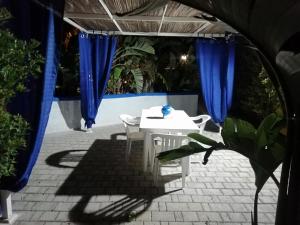 a white table and chairs on a patio with blue curtains at Sole&Mare in Monopoli