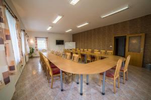 a conference room with a large wooden table and chairs at Hotel Elsyn Dvůr in Stachy