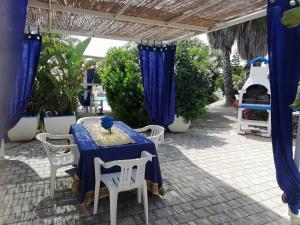 a blue table and chairs under a pergola at Sole&Mare in Monopoli