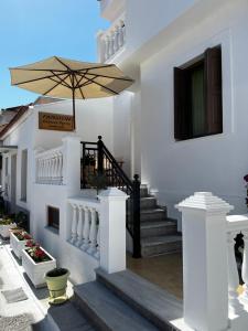 Casa blanca con una escalera con sombrilla en Pansion Giannis Perris en Kokkari