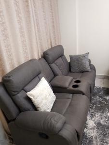 Jamhuri Executive Suites في نيروبي: أريكة جلدية بنية في غرفة المعيشة