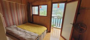 ein kleines Schlafzimmer mit einem Bett und einem Balkon in der Unterkunft Du Gia View Homestay in Làng Cac