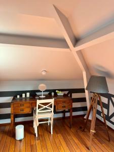 a desk and a tripod in a room with striped walls at La Borzeux in Stavelot
