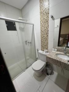 een badkamer met een toilet, een douche en een wastafel bij Hotel Vale da Serra in Parauapebas