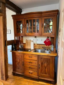 eine Küche mit Holzschränken und einem Waschbecken in der Unterkunft Schloßbergwohnung Löwenhaus in Homberg