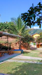 un pabellón con bancos y una palmera en un parque en Pousada Casa da montanha en Casimiro de Abreu