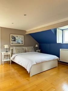 a bedroom with a large bed with a blue wall at La Borzeux in Stavelot