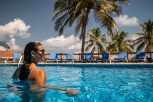 una mujer en la piscina de un complejo en SunBreeze Hotel, en San Pedro