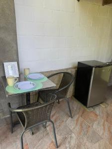 a table with two chairs and a small refrigerator at Villa Isa in Cali