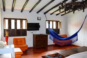 a living room with a blue hammock in a room at Casona Quesada in Suesca