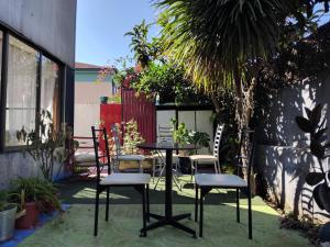 un patio con una mesa, sillas y una palmera en Hotel Montealegre, en Valparaíso