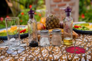 a table topped with bottles and plates of food at Volcano Vacation Rooms in Gasanze