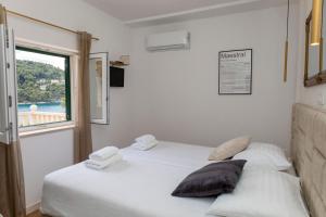 2 letti in una camera con finestra di Lučica, Luxury Rooms By the Sea a Pučišća