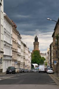 a city street with buildings and a clock tower at Sir Tobis Apartments - Sonnenhof - Zentrumsnah - Modern in Görlitz