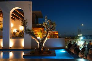 a tree in the middle of a pool at night at Vaya Suites by Omilos Hotels in Amoudara Herakliou