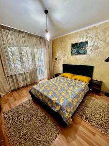 1 dormitorio con 1 cama con almohadas amarillas y alfombra en Elina apartament, en Drobeta-Turnu Severin