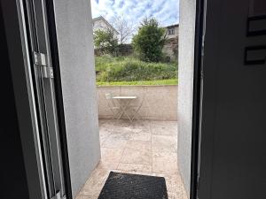 an open door to a patio with a table outside at Petite Maison studio tout confort cosy Givors autoroute et gare in Givors