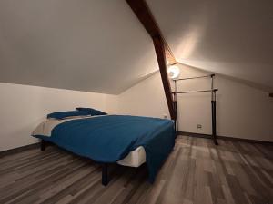 a bedroom with a bed with a blue blanket at Petite Maison studio tout confort cosy Givors autoroute et gare in Givors