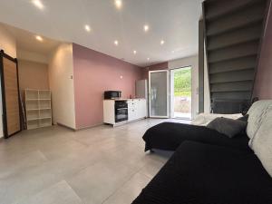 a living room with a bed and a kitchen at Petite Maison studio tout confort cosy Givors autoroute et gare in Givors
