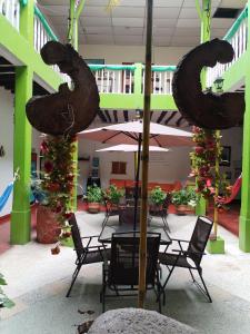 a table with chairs and an umbrella in a building at Hostel La Casona 1859 in Guaduas