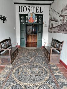 a room with two benches in front of a hostel at Hostel La Casona 1859 in Guaduas