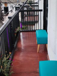 a blue bench sitting on a balcony next to a railing at Hostel La Casona 1859 in Guaduas