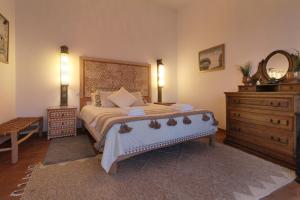 una camera da letto con un letto con un comò e uno specchio di Fonte dos Pássaros a Vila Nova de Milfontes