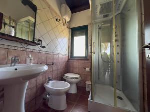 a bathroom with a sink and a toilet and a shower at Villabosco in Favara +70 photos