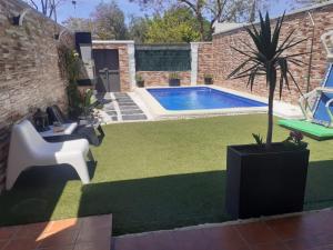 a backyard with a pool and a chair and a palm tree at Casa Adosada in Bormujos +17 photos