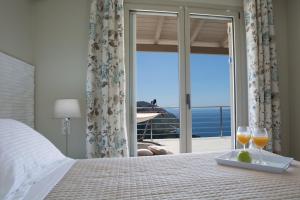 a bedroom with a bed with two glasses of wine at Ilios villa in Fternón