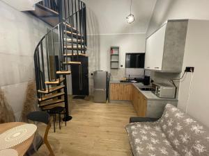 a kitchen with a spiral staircase in a kitchen at Domki pod Dębami in Choczewo