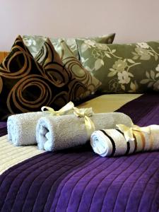 un paio di asciugamani su un letto con fiocchi di B&B Zmajevo Gnezdo 021 a Sremska Kamenica
