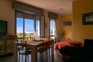 a dining room with a table and chairs and a bedroom at Villa La Magnolia - Private Beach Access, Garden, Views in Lazise