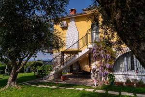 a yellow house with a staircase in the yard at Villa La Magnolia - Private Beach Access, Garden, Views in Lazise