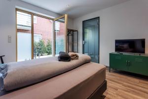 a bedroom with a large bed with a tv on it at City-Apparte Boarding -Studios- Dein flexibles Zuhause in Gronau in Gronau