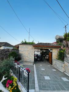 un edificio de ladrillo con un garaje con motocicletas en Kore Guest House en Gjirokastër